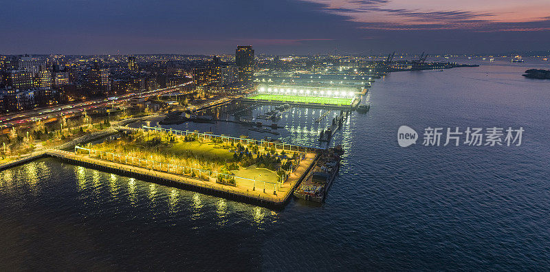 布鲁克林大桥公园，东河夜景璀璨。布鲁克林-皇后区高速公路(Brooklyn- queens Expressway)和布鲁克林高地步道(Brooklyn Heights Promenade)在公园后面。商业码头和Verrazzano-Narrows桥的远景。